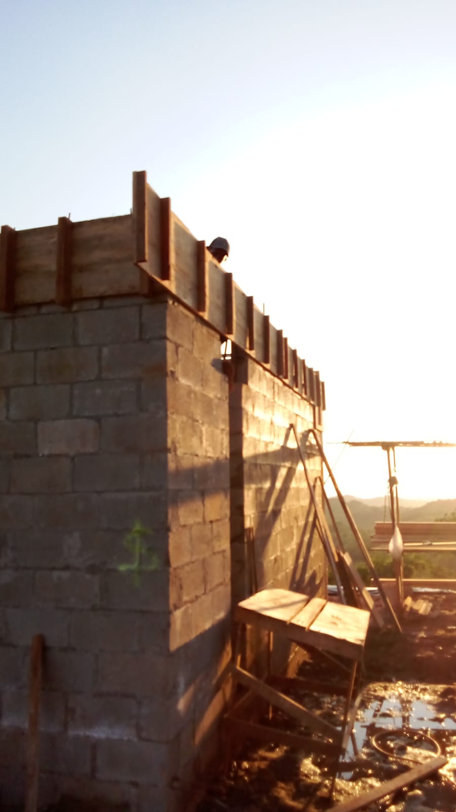Se observa una estructura de bloques de concreto en construcción con encofrado de madera en la parte superior.