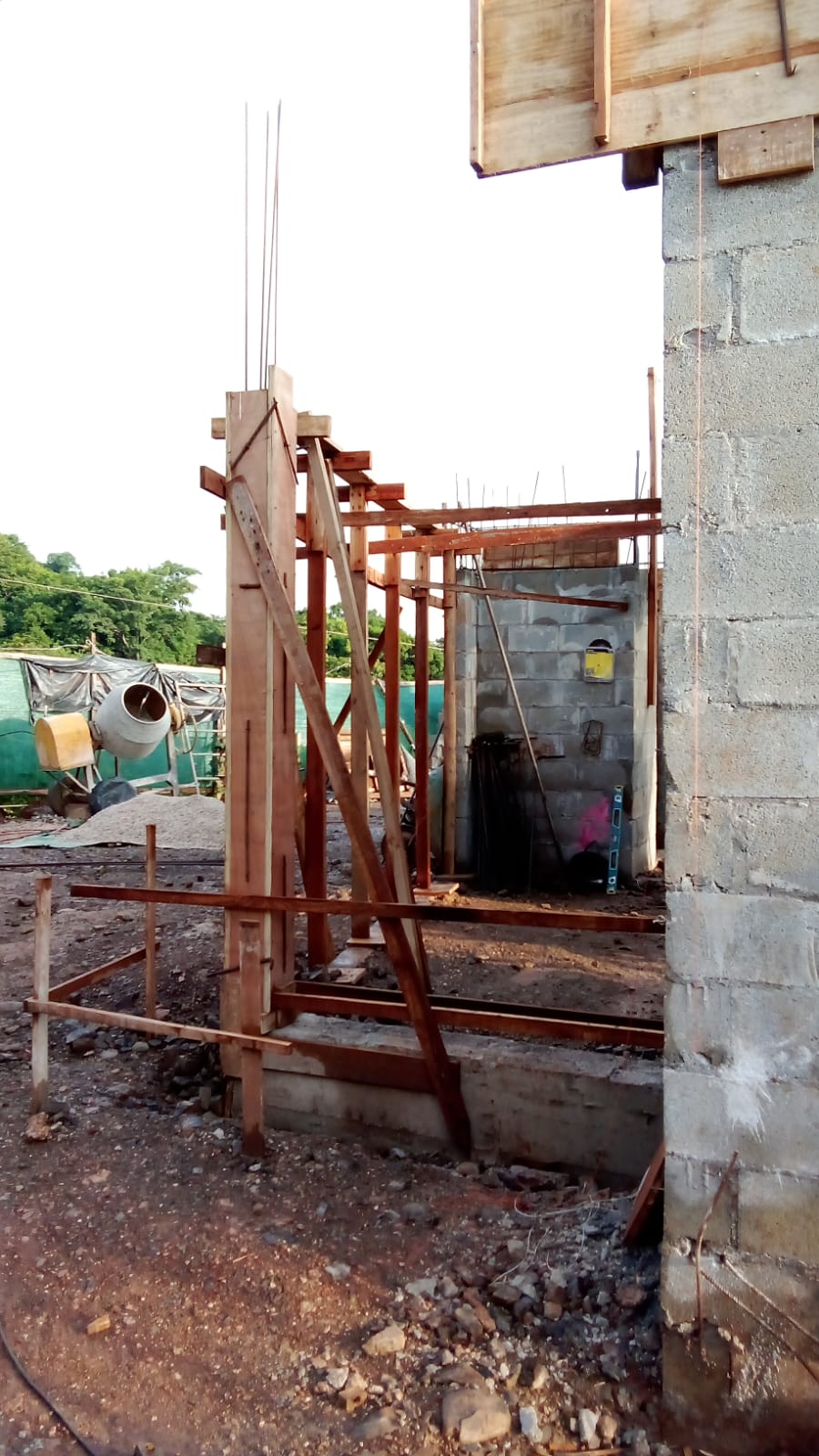 Se observa una estructura de construcción en proceso con encofrados de madera y bloques de concreto.