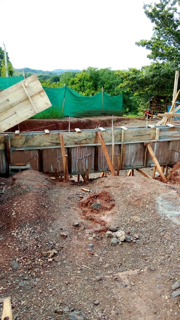 Se observa una obra de construcción con encofrados de madera y metal para una estructura de cimentación.