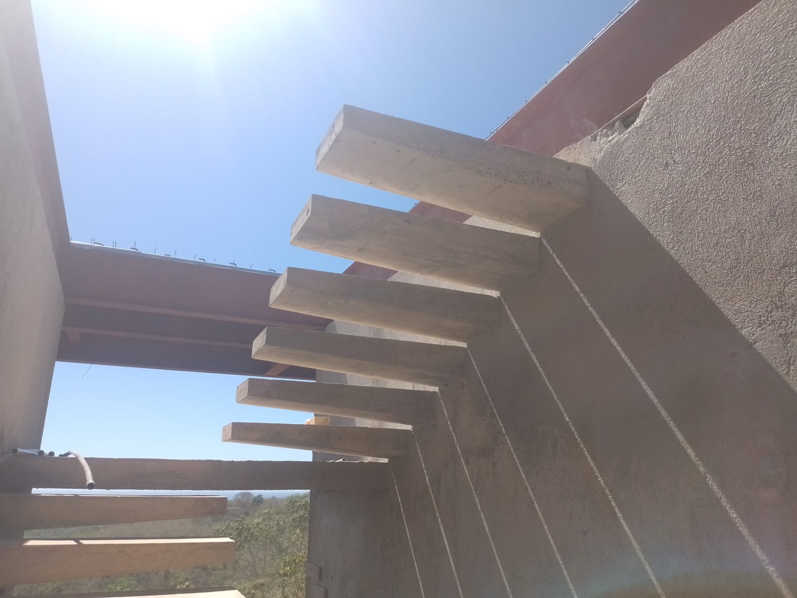Se observa una estructura de vigas de concreto en voladizo en una construcción al aire libre.