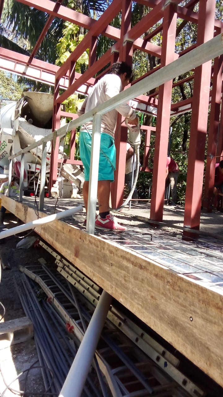 Un trabajador utiliza una herramienta eléctrica en una estructura metálica durante una obra de construcción.