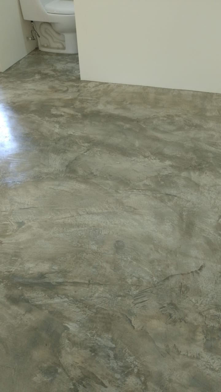 Se muestra un piso de concreto pulido con acabado texturizado en un espacio interior.